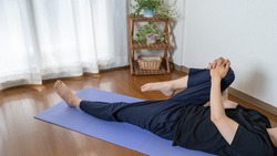 A man stretching at home. Gluteus maximus stretch. Lower body stretch. Stretching the legs.