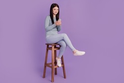 Full size profile side photo of young girl look browse cellphone sit stool isolated over purple color background