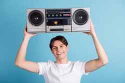 Photo of nice glad guy hold boom box wear t-shirt isolated blue color background.