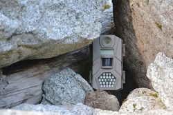 Rugged wildlife camera trap hidden among the rocks in the mountains of Western Washington.