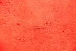 Bright orange red color Background. Abstract stonewall backdrop. Stucco Wall painted in red orange color. Rough Surface plaster Texture. Beautiful Wallpaper with Copy Space for Design