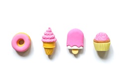 Different toy sweets in miniature with soft shadows close-up isolated on a white background.