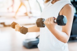 Blurred Woman Lifting Dumbbells in Weight Training Fitness - Sport and Lifestyle Concept