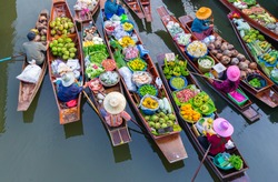 Top view Thailand traditional ancient floating market on the morning with some mist , they are on the local river for exchanging the agriculture food, fruit and vegetable.