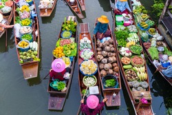 Top view Thailand traditional ancient floating market on the morning with some mist , they are on the local river for exchanging the agriculture food, fruit and vegetable.
