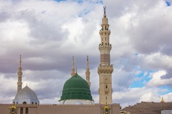 The famous Green Dome of the Holy Prophet's Mosque in Madinah, Saudi Arabia with beautiful blue sky with clouds.