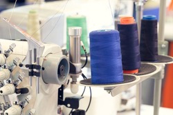Reels of textile yarn blue thread at industrial weaving manufacturing machine