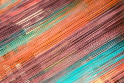 Multicolored straight strands texture background, sewing equipment, loom equipment at a garment factory