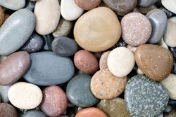 Smooth round wet pebbles texture background. Pebble sea beach close-up