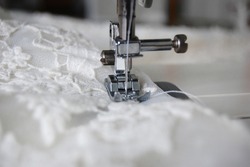 Close up of a sewing machine making alterations of a bride's wedding dress.