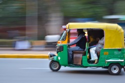 Auto rickshaws are a popular mode of transportation in India for last mile travel. The photograph shows the panned shot of an Auto speeding on the road