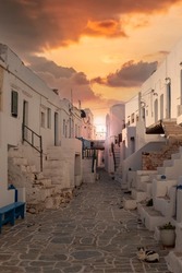 Amazing sunset at Folegandros island, Greece, in a picturesque alley of the village Chora, the capital of the island. Folegandros belongs to the Cyclades islands, in the Aegean Sea, Greece, Europe. 