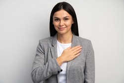 I swear. Portrait of responsible serious businesswoman in business suit holding hand to take oath, promising to be honest, telling truth, pledging allegiance. Studio shot isolated on white background 