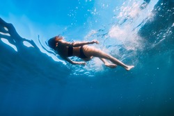 Young woman in bikini floating in blue sea. Activity summer days at sea