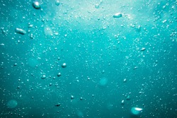 Underwater turquoise texture in ocean. Bubbles in tropical sea. 