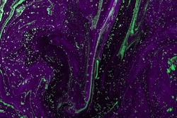 Abstract paint texture art. Natural luxury. Purple paint with green glitter powder. Marble background.