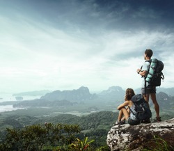 Young backpackers enjoying a valley view from top of a mountain