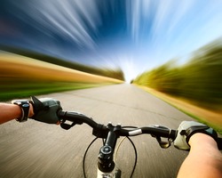 Rider driving bicycle on an asphalt road. Motion blurred background