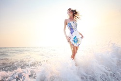 Young smiling woman having fun standing in sea water