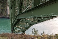 an old green bridge crossing from one cliff to another