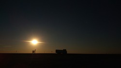 A big truck on the desert horizon in the sunset rays