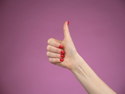 Hand with thumb up isolated on purple background. Ok sign by woman