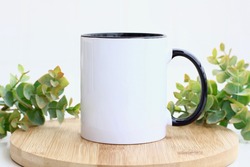 Blank black handle mug mockup photo with eucalyptus ,black rim mug on wood table