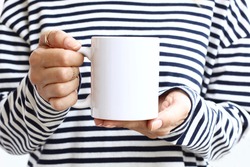 Girl in  striped sweatshirt holding white coffee mug , white porcelain mug mock up. 11 oz mockups
