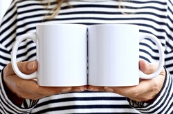 Girl in  striped sweatshirt holding white coffee mug. 2 white porcelain mug mock up. 11 oz mockups for front back design