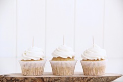 3 white cupcakes with stick for toppers on wood stand , cupcake mock up