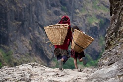 Nepali children in national clothes with baskets on mountain path