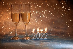 2022 New Year. Happy new year 2022 greeting card. Champagne glasses on glitter background