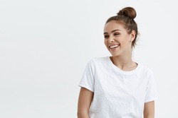 Portrait of emotive good-looking caucasian woman laughing while looking aside and standing against white background. Positive housewife on shopping with kids. Fashionable girl talks with friends