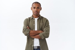 Young serious-looking, confident african american male employee, cross hands chest, waiting for appointment, apply for job position, look determined, standing white background