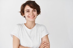 Close-up of happy professional girl cross arms on chest, smiling at camera, white background. Copy space
