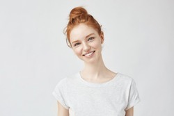 Portrait of young beautiful ginger woman with freckles cheerfuly smiling looking at camera. Isolated on white background. Copy space.