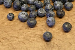 Natural wooden background. Food background. Blueberries ripe and tasty on a wooden table. A large plan, a top view, rustic style.