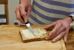 Woman hands spread bread with butter. High quality photo