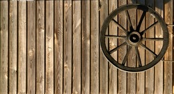 decorative rural wooden wheel in wooden background. an old horse-drawn carriage made of wood attached to the wall of a wooden log house. . High quality photo