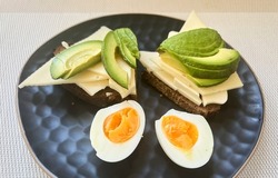 Sandwiches with cheese, avokado and eggs on black plate background. Healthy food. Diet concept. High quality photo