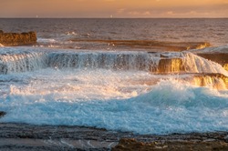 Ocean coastline scene with waves crushing over rocks at sunrise. Sunset, sunrise seascape nature background 