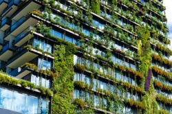 Green skyscraper building with plants growing on the facade. Ecology and green living in city, urban environment concept. Park in the sky, One central park building, Sydney, Australia
