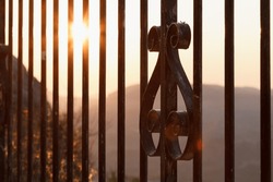Dawn over the wrought iron fence of the San Cristobal viewpoint in Alcoy, Spain