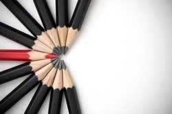 The red pencil is prominent and is surrounded by a black pencil. Leadership, uniqueness, think different, teamwork business success