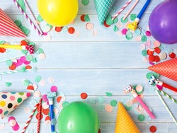 Frame or background with colorful balloon, confetti, carnival cap and streamer. Flat lay style. Used for birthday or party greeting card with center copy space.