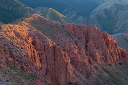Beautiful red clay mountains eroded on wind. Red mountains or red canyon on the way from Assy plateau to Bartogai reservoir. Mountain canyon landscape. Travel, tourism in Kazakhstan concept.