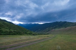 Beautiful mountains with heavy clouds. Thunderstorm, bad weather in the mountains concept. Gorge near Saty village. Travel, tourism in Kazakhstan concept. Sky clouds background. Scenic background.