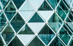 Aluminum triangle geometry of modern  building glass facade urban architecture with reflection. Futuristic Architecture design.