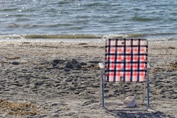 Lonely folding chair with shoe under it on beautiful beach