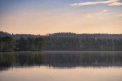 View over a lake in Sweden in Smalland with forest on the other shore. Wild nature in Scandinavia. Landscape photo from the north